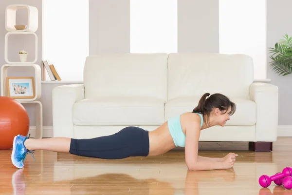 Fit brünette in plank position — Stockfoto