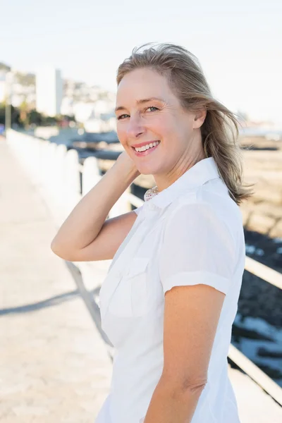 Casual vrouw die lacht op camera door de zee — Stockfoto