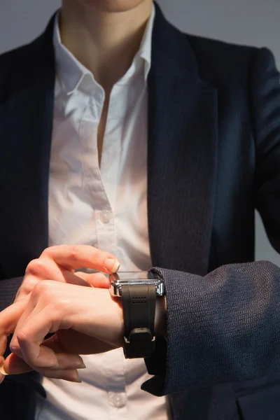 Businesswoman in suit checking the time — Stock Photo, Image