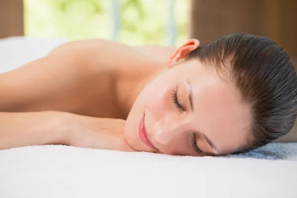 Beautiful woman lying on massage table at spa center — Stock Photo, Image