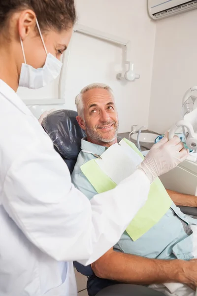 Paciente sonriendo al dentista en la silla — Foto de Stock