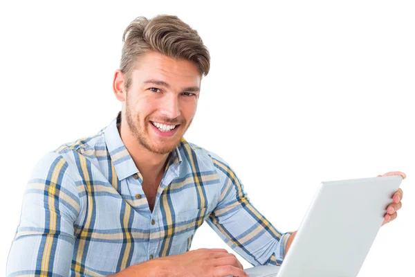 Guapo joven sentado usando el ordenador portátil — Foto de Stock