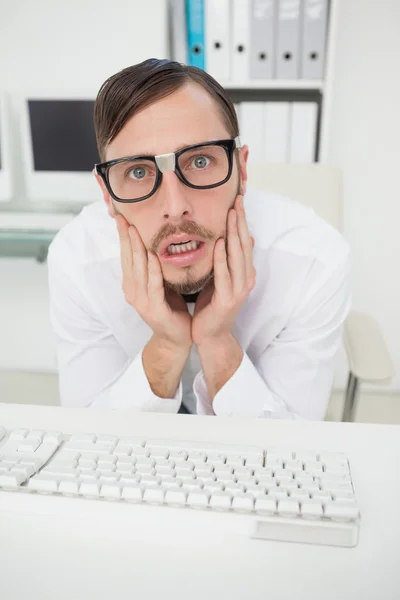 Nerdy nervous businessman working on computer — Stock Photo, Image