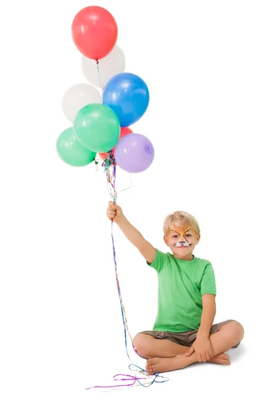 Happy little boy in tiger face paint with balloons — Stock Photo, Image