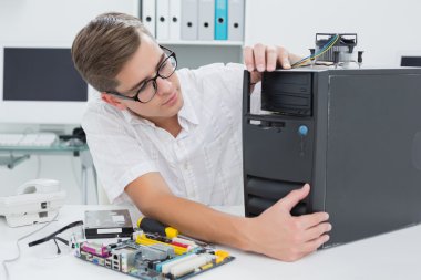 Young technician working on broken computer clipart