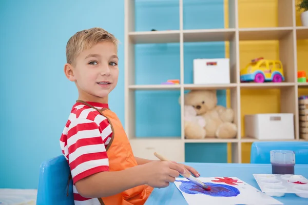 Little boy painting at table in classroom — Stock Photo, Image