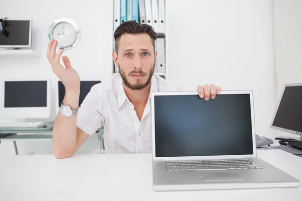 Förvirrad dataingenjör tittar på kameran med laptop — Stockfoto