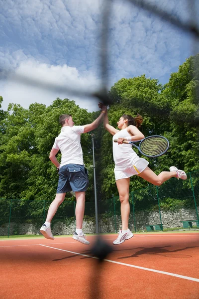 Tennis doubles team celebrating a win — Stock Photo, Image