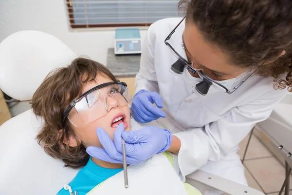 Pediatric dentist examining a little boys teeth in the dentists — Stock Photo, Image