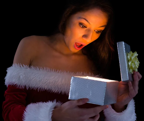 Mooie brunette in santa outfit opening cadeau — Stockfoto