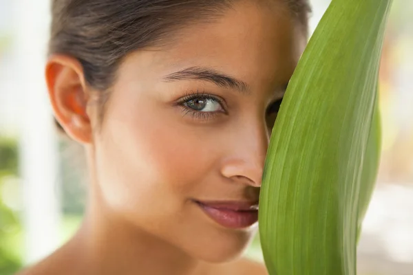 Krásná brunetka s zelený list — Stock fotografie
