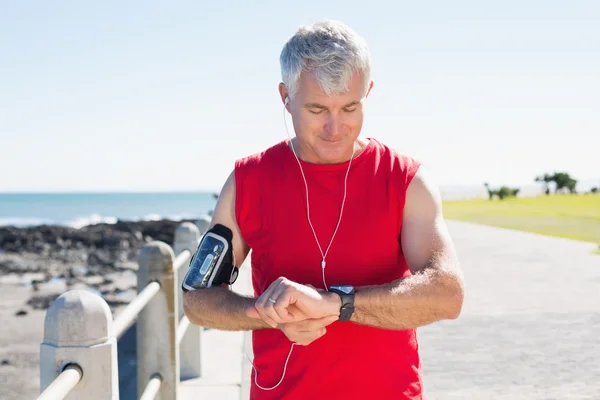 Fit mature man checking the time on the pier