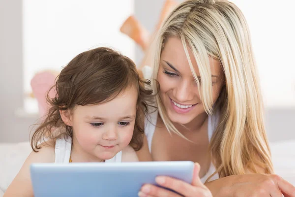 Mère et fille utilisant une tablette numérique sur le lit — Photo