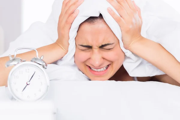 Mujer cubriendo orejas con sábana en cama — Foto de Stock