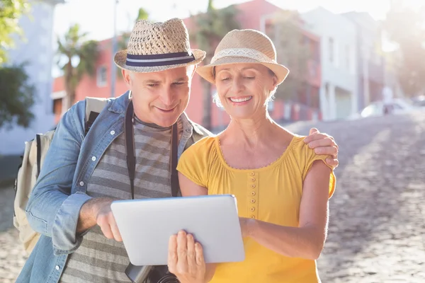 Happy tourist couple using tablet pc in the city — Stock Photo, Image