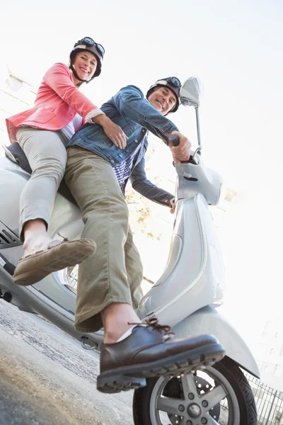 Happy senior couple riding a moped — Stock Photo, Image