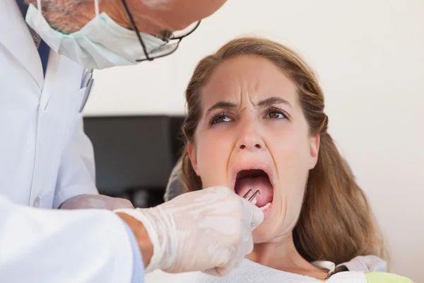 Dentist about to pull a terrified patients tooth — Stock Photo, Image