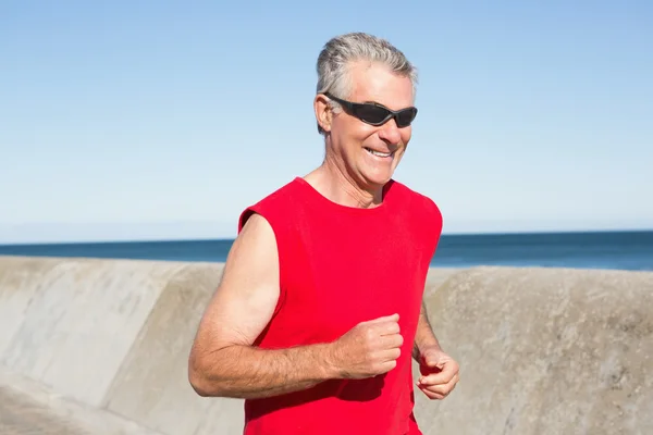 Uomo anziano attivo che fa jogging sul molo — Foto Stock