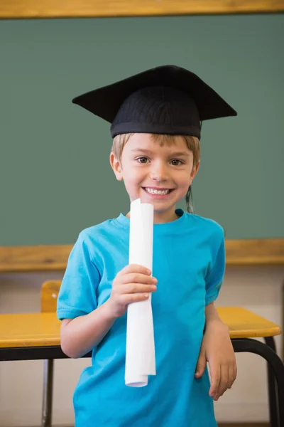 Pupil in mortar board in classroom — Stock Photo, Image