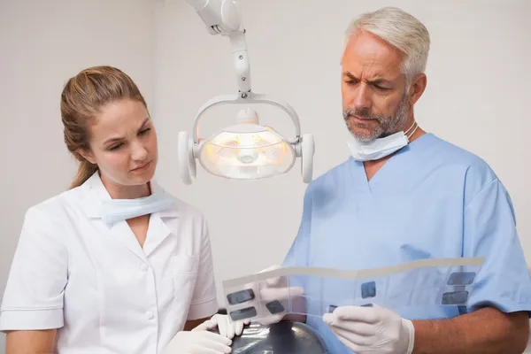 Dentista e assistente estudando raios-X — Fotografia de Stock