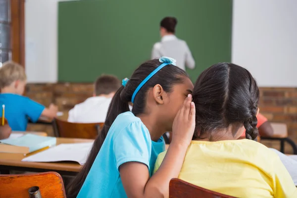 Pupils whispering in classroom — Stock Photo, Image