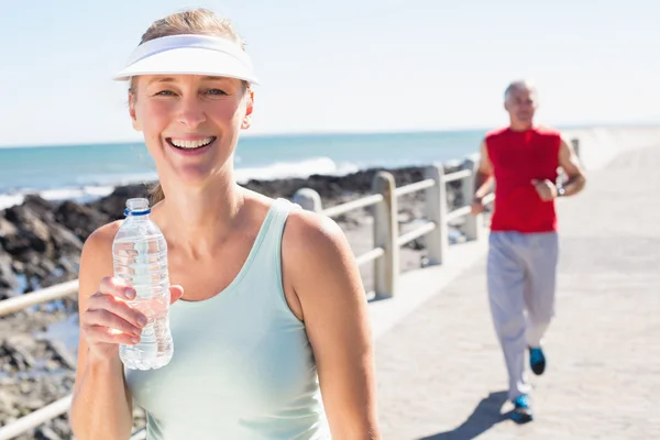 Fit mature couple jogging together on the pier — Stock Photo, Image
