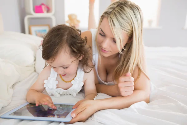 Matka a dcera pomocí digitálních tabletu na posteli — Stock fotografie