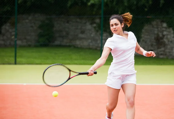 Jolie joueuse de tennis frappant la balle — Photo