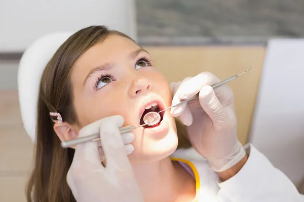Dentiste examinant une petite fille dents — Photo