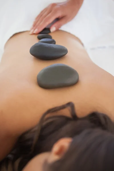 Brunette enjoying hot stone massage — Stock Photo, Image