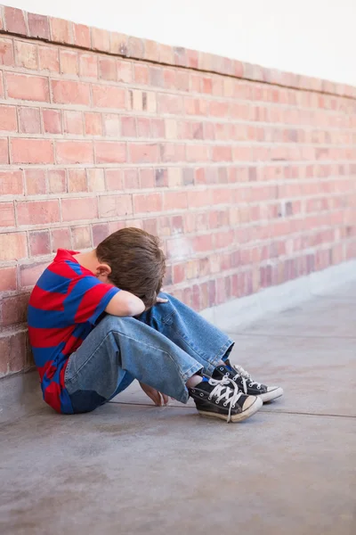 Triste alumno sentado solo en el pasillo — Foto de Stock