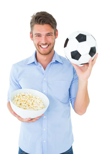 Przystojny młody mężczyzna trzyma piłkę i popcorn — Zdjęcie stockowe
