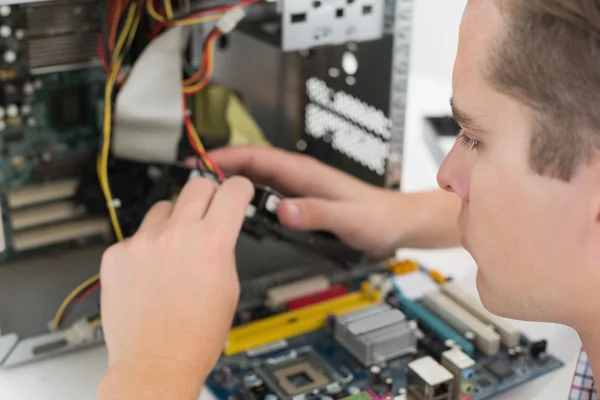 Joven técnico trabajando en una computadora rota — Foto de Stock