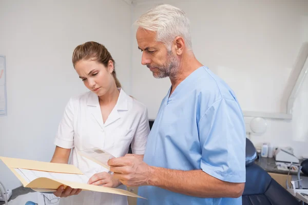 Dentista e assistente che studia i raggi X — Foto Stock