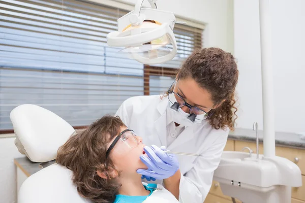 Pediatric dentist examining a little boys teeth in the dentists — Stock Photo, Image