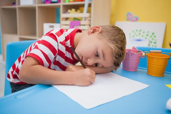 Netter kleiner Junge zeichnet am Schreibtisch — Stockfoto