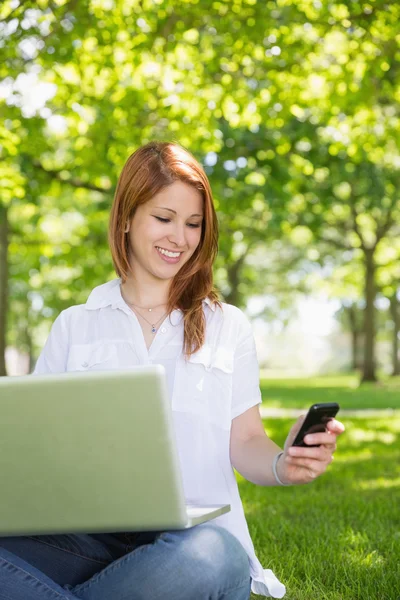 Rossa utilizzando il suo computer portatile durante il sms — Foto Stock