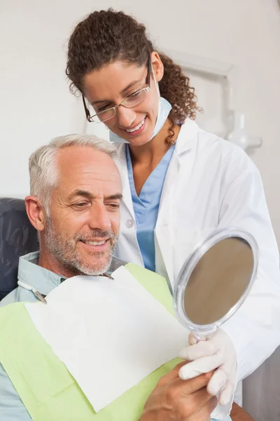 Patient admiring his new smile in the mirror — Stock Photo, Image
