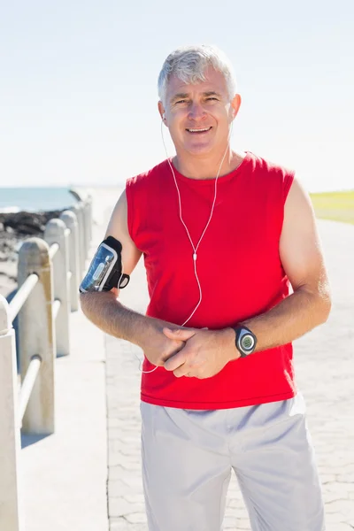 Fitter älterer Mann lächelt auf dem Pier in die Kamera — Stockfoto