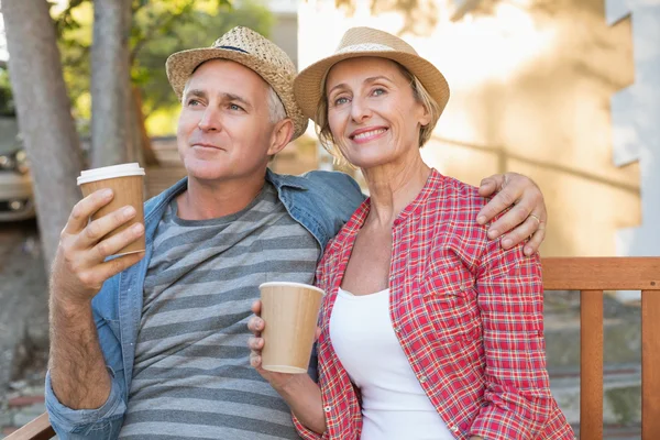 Feliz pareja adulta tomando café en un banco de la ciudad — Foto de Stock