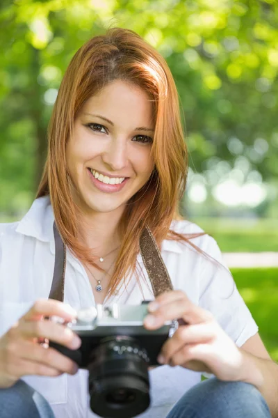 Redhead holding her camera in the park — Stock Photo, Image