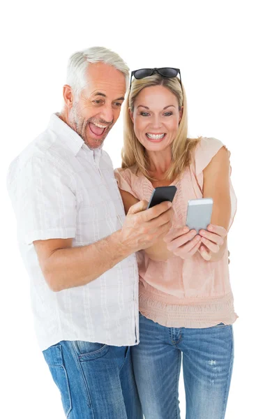 Счастливая пара смотрит на свои смартфоны — стоковое фото