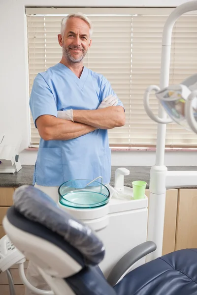 Dentista en uniforme azul sonriendo a la cámara — Foto de Stock