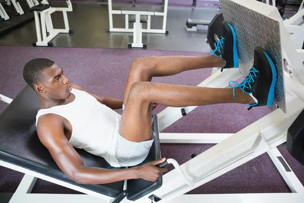 Levantador de pesas haciendo prensas de piernas en el gimnasio — Foto de Stock