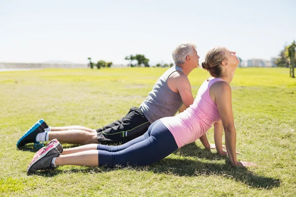 Past volwassen paar opwarmen op het gras — Stockfoto