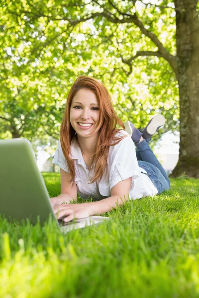 Ruiva usando laptop no parque — Fotografia de Stock