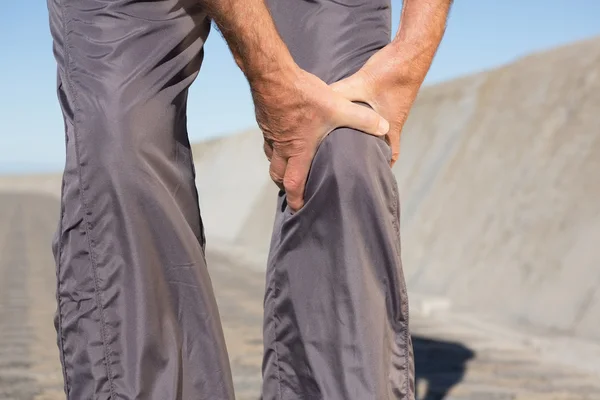 Aktivní starší muž dotýká zraněné koleno — Stock fotografie