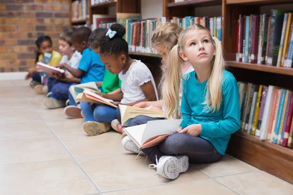 Elèves assis sur le sol dans la bibliothèque — Photo