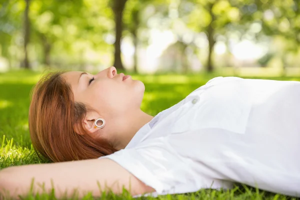 Pěkná zrzka ležící na trávě relaxační — Stock fotografie