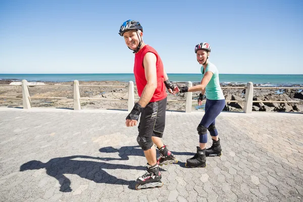 Apto casal maduro patinagem no cais — Fotografia de Stock